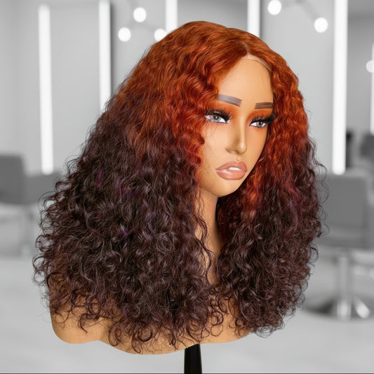 Side view of A mannequin head showcases NuHaire's 13x4 T-Part Ginger Ombre 4/350 Curly Wave Lace Front Human Hair Wig. The wig features a flawless ombre transition from ginger to brown, made from premium human hair. It includes a transparent lace front, a natural hairline, and beautiful, flowing curly waves.