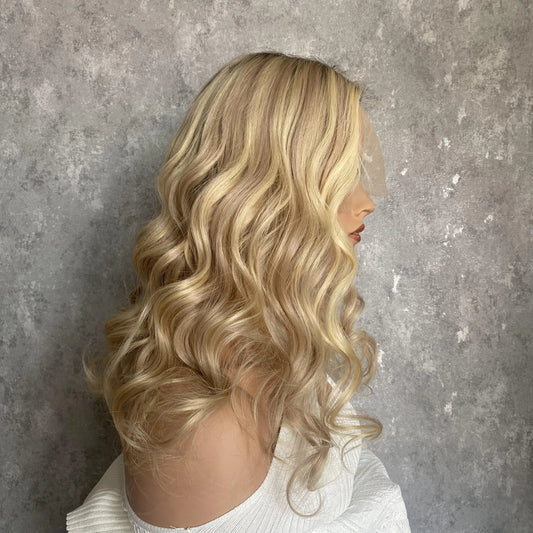 Side view of sunny blonde balayage natural wave wig displaying sun-kissed dimension and European human hair