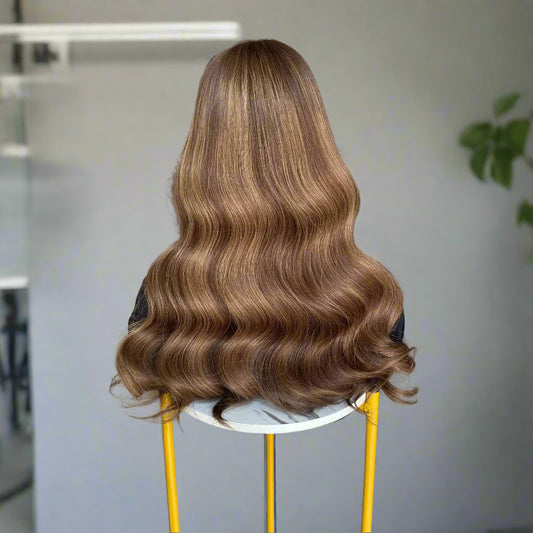 Back view of long, European human hair, featuring an Espresso Brown Balyage loose wavy brown 9x5 glueless mono lace wig, set on a chair indoors.