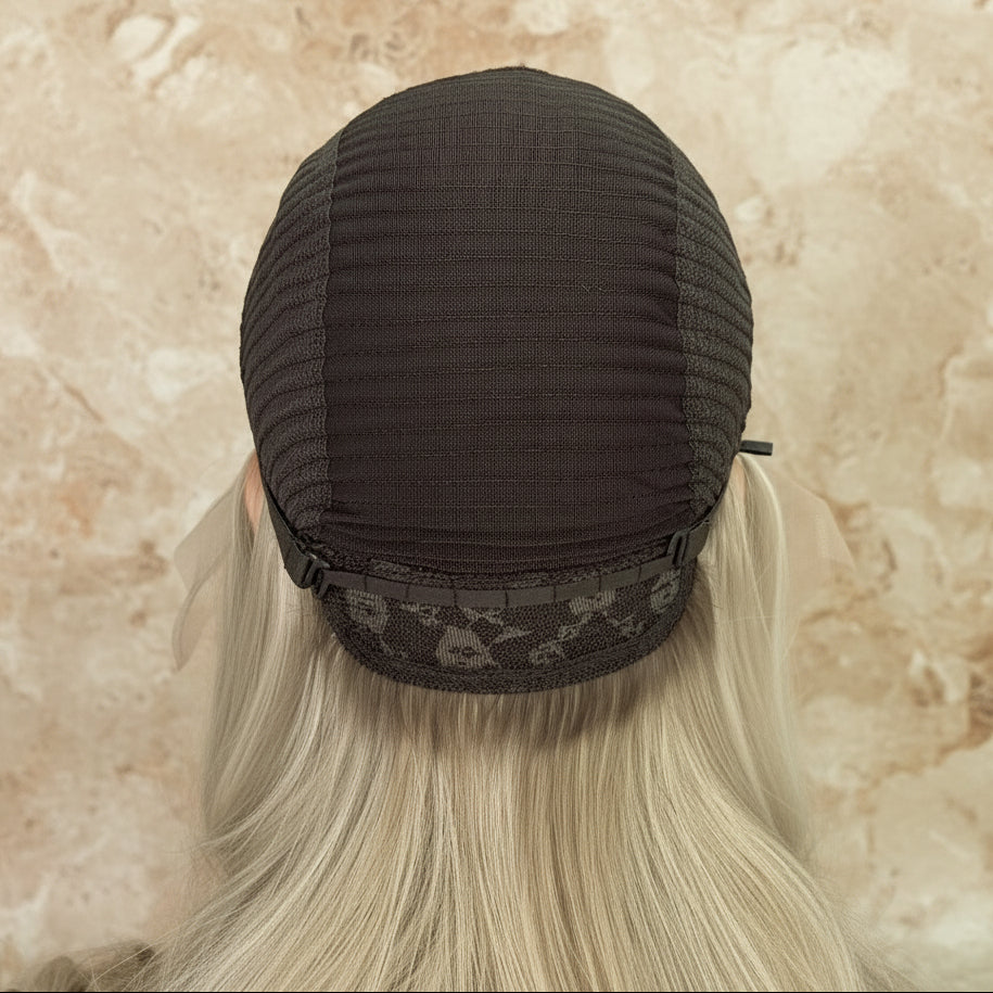 Back view of pearl ash blonde wig cap construction showcasing hand-tied craftsmanship and lace quality