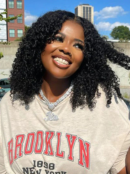 A woman is outside wearing a beginner-friendly NuHaire Kinky Curly human hair wig with 180% density, providing full volume from root to tip, and a seamless blend of a 6x4 HD glueless lace closure.