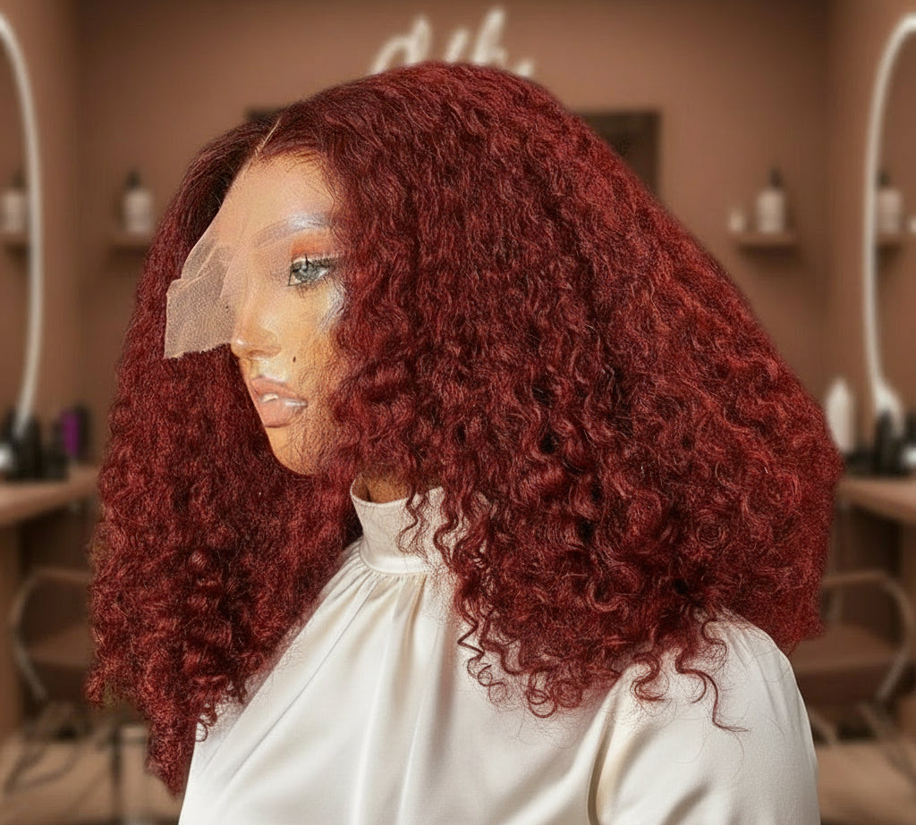 Side view of mannequin head showcasing the NuHaire 99J Burgundy Kinky Curly 5*5 /13*4 Transparent Lace Human Hair Wig, featuring a rich burgundy color, premium quality grade human hair, transparent lace front, natural hairline, and bouncy kinky curly texture.