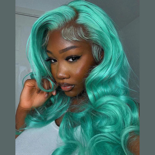 Up close view of A model showcasing a mint green body wave lace front wig by NuHaire, designed with 13x4 natural hairline and transparent lace.