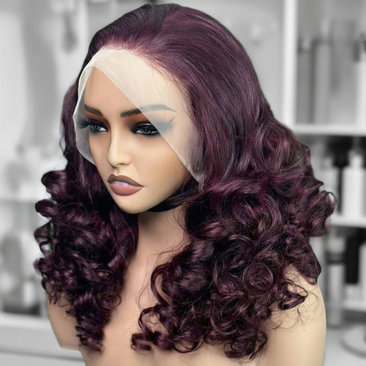 Side view of A mannequin head wearing NuHaire's 99J Burgundy Full Density Bouncy Egg Curly Lace Front Human Hair Wig, showcasing a flawless burgundy hair color, premium human hair quality, transparent lace front, natural hairline, and bouncy egg curl texture.