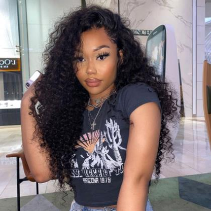 A person wearing NuHaire's kinky curly 13x6 lace front wig with a pre-plucked, pre-bleached hairline. The wig features a natural black color, full 250% density, and skin-melt HD lace against a neutral background.
