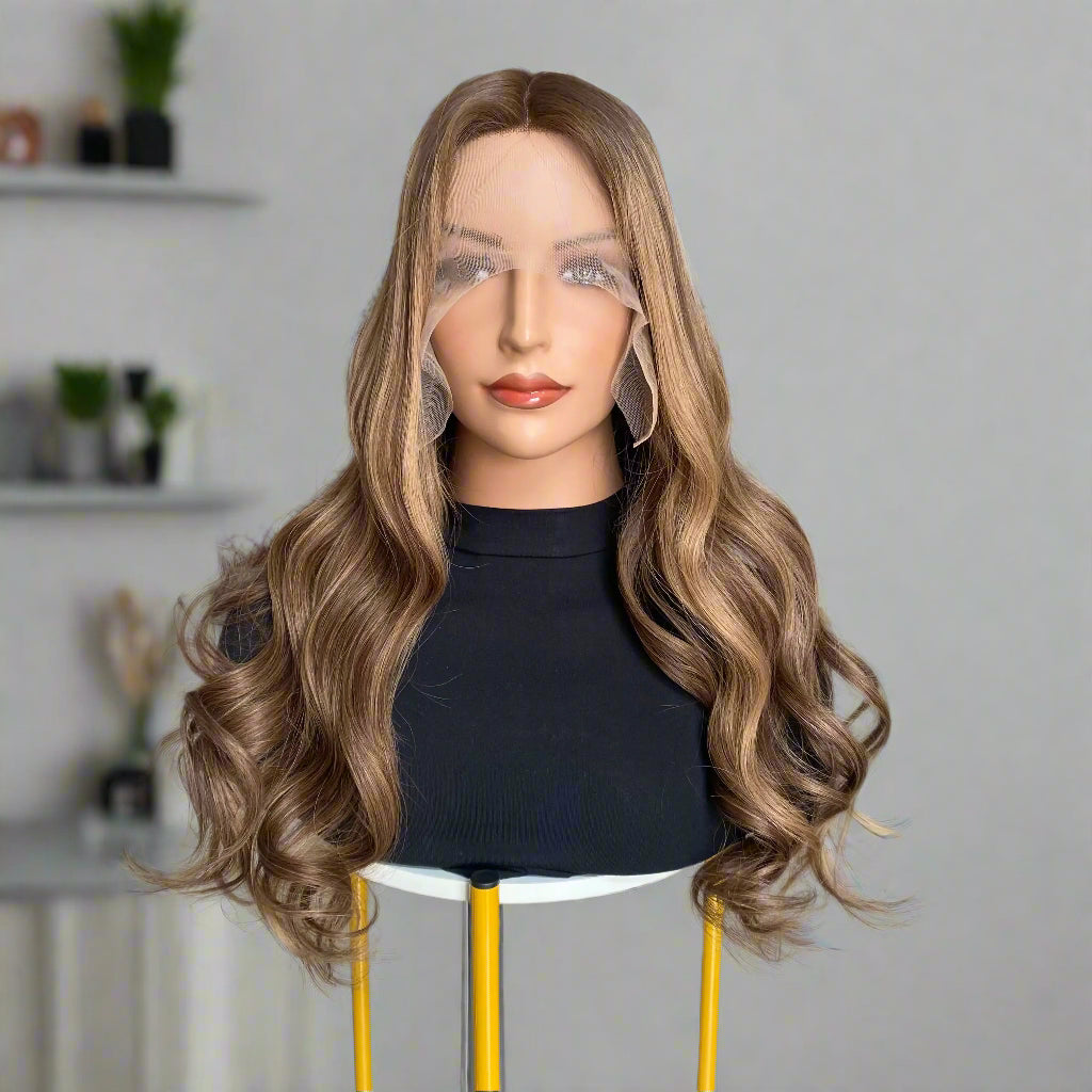 Mannequin head with long, European human hair, featuring an Espresso Brown Balyage loose wavy brown 9x5 glueless mono lace wig, set on a chair indoors.
