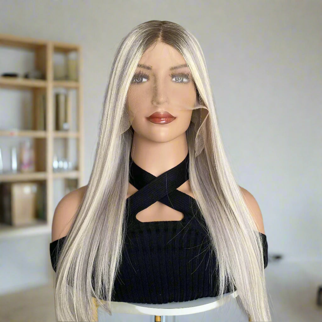 Mannequin head with long blonde wig in a room with shelves and decor.
