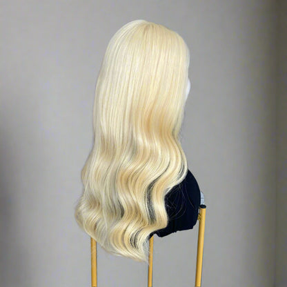 Side view of 613 light Blonde Glueless European human hair body wave wig on a mannequin head in a hair product display area.