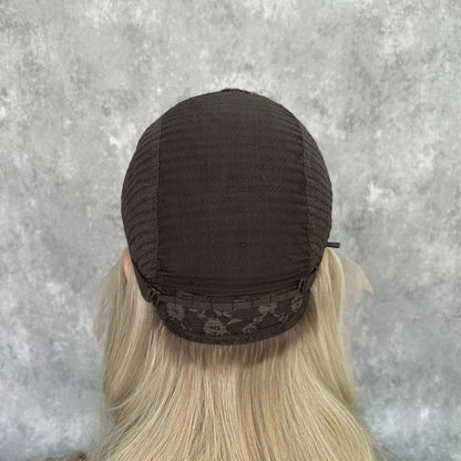 Back view of pearl ash blonde wig cap construction showcasing hand-tied craftsmanship and lace quality