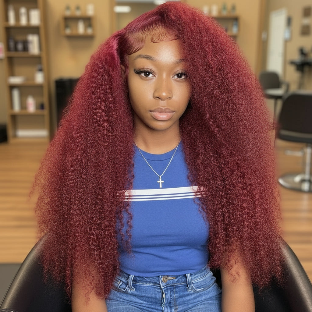 A Model showcasing the NuHaire 99J Burgundy Kinky Curly 5*5 /13*4 Transparent Lace Human Hair Wig, featuring a rich burgundy color, premium quality grade human hair, transparent lace front, natural hairline, and bouncy kinky curly texture.