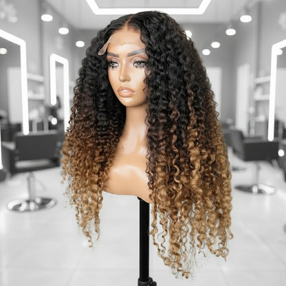 Side view of Mannequin head showcases NuHaire's Three Color 1B/4/27 Ombre Deep Wave Wig. This wig features a natural transition from black to brown to honey blonde, a flowing deep wave texture, a full 250% density, premium human hair, and a skin-melt 13x4 transparent lace.
