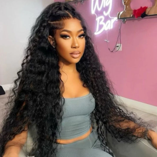13x4/13x6 Deep wave transparent lace front human hair wig freshly installed on model showing deep wave texture, natural hairline,  long length, and styling versatility of half up/half down hair style in a hair salon