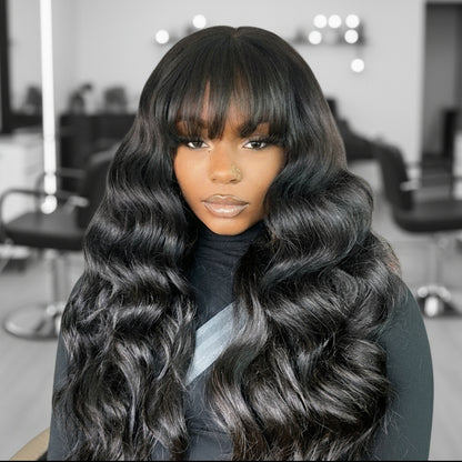 Model showcases NuHaire's Ready to Wear Loose Wave Wig with Bangs, featuring a natural black color, flowing loose wave texture, glueless install with bangs, and premium human hair.