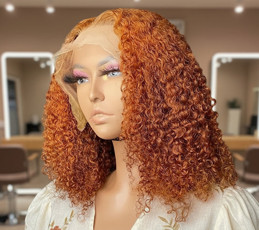 A mannequin head wearing NuHaire's Ginger Curly Bob, showcasing a flawless ginger #350 hair color, premium human hair quality, 13x4 lace front, natural hairline, and bouncy curly texture.