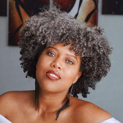 Woman wearing salt and pepper kinky curly bob wig with bangs showing natural gray color blend
