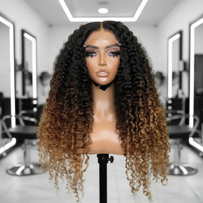 Mannequin head showcases NuHaire's Three Color 1B/4/27 Ombre Deep Wave Wig. This wig features a natural transition from black to brown to honey blonde, a flowing deep wave texture, a full 250% density, premium human hair, and a skin-melt 13x4 transparent lace.